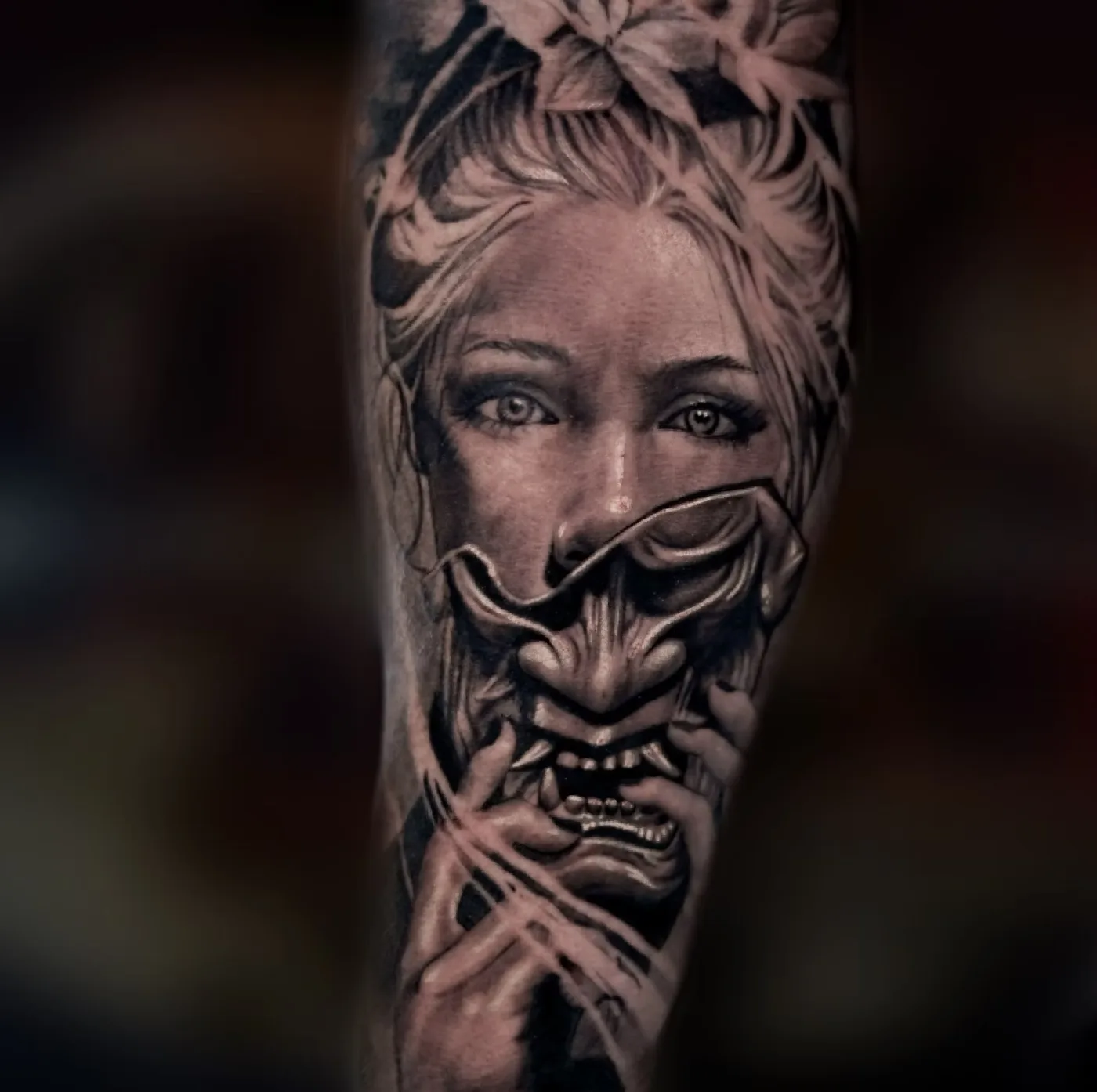 Black and grey sleeve of a geisha behind a hannya mask