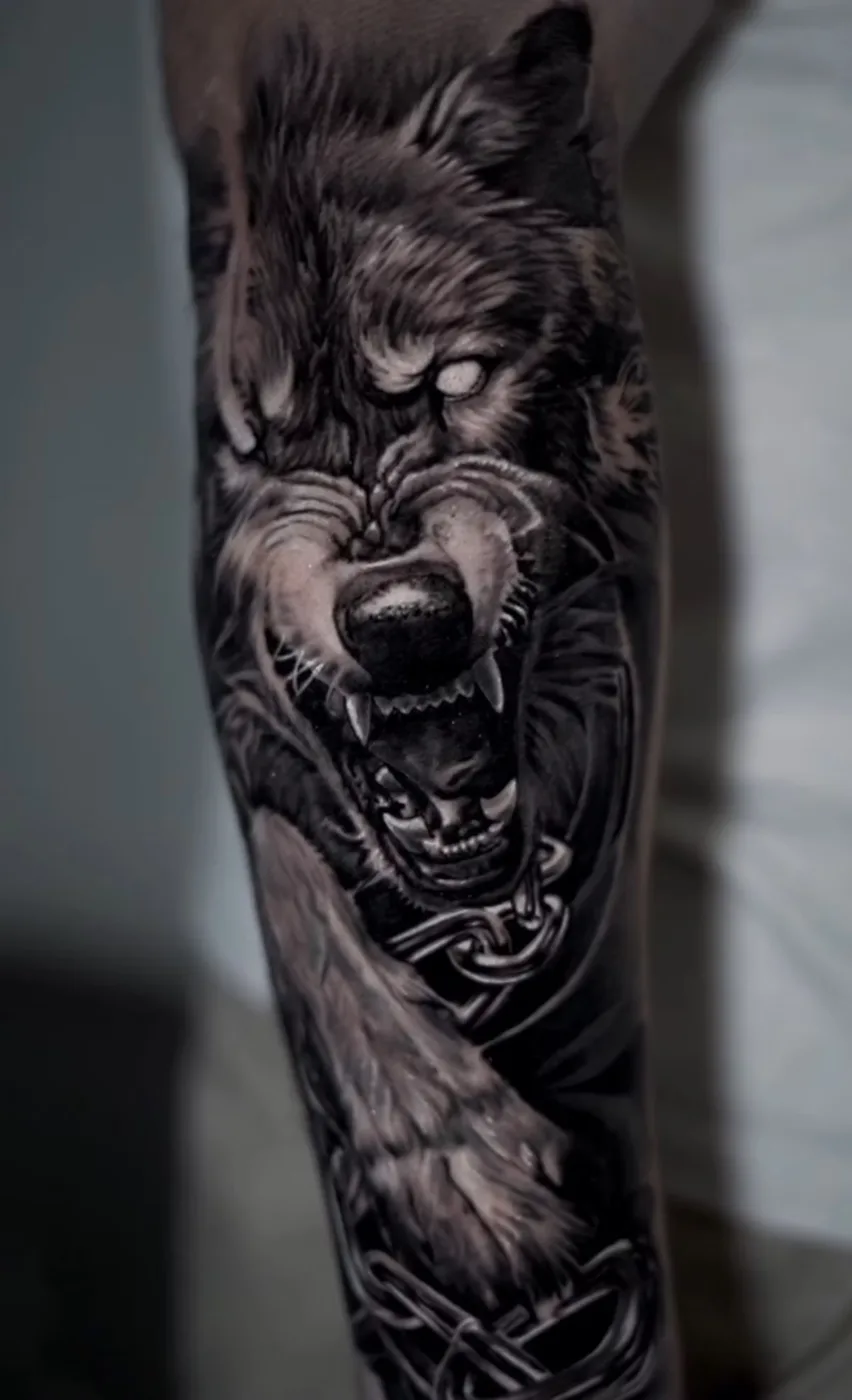 Forearm tattoo of a snarling wolf wrapped in chains